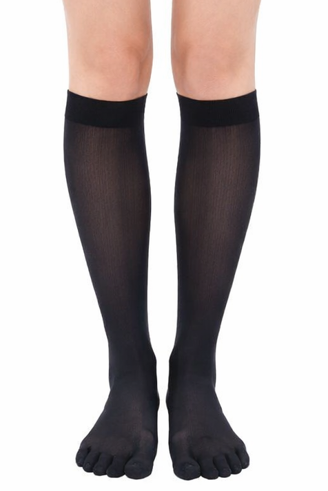 Black knee-high socks worn with black shorts on a white background