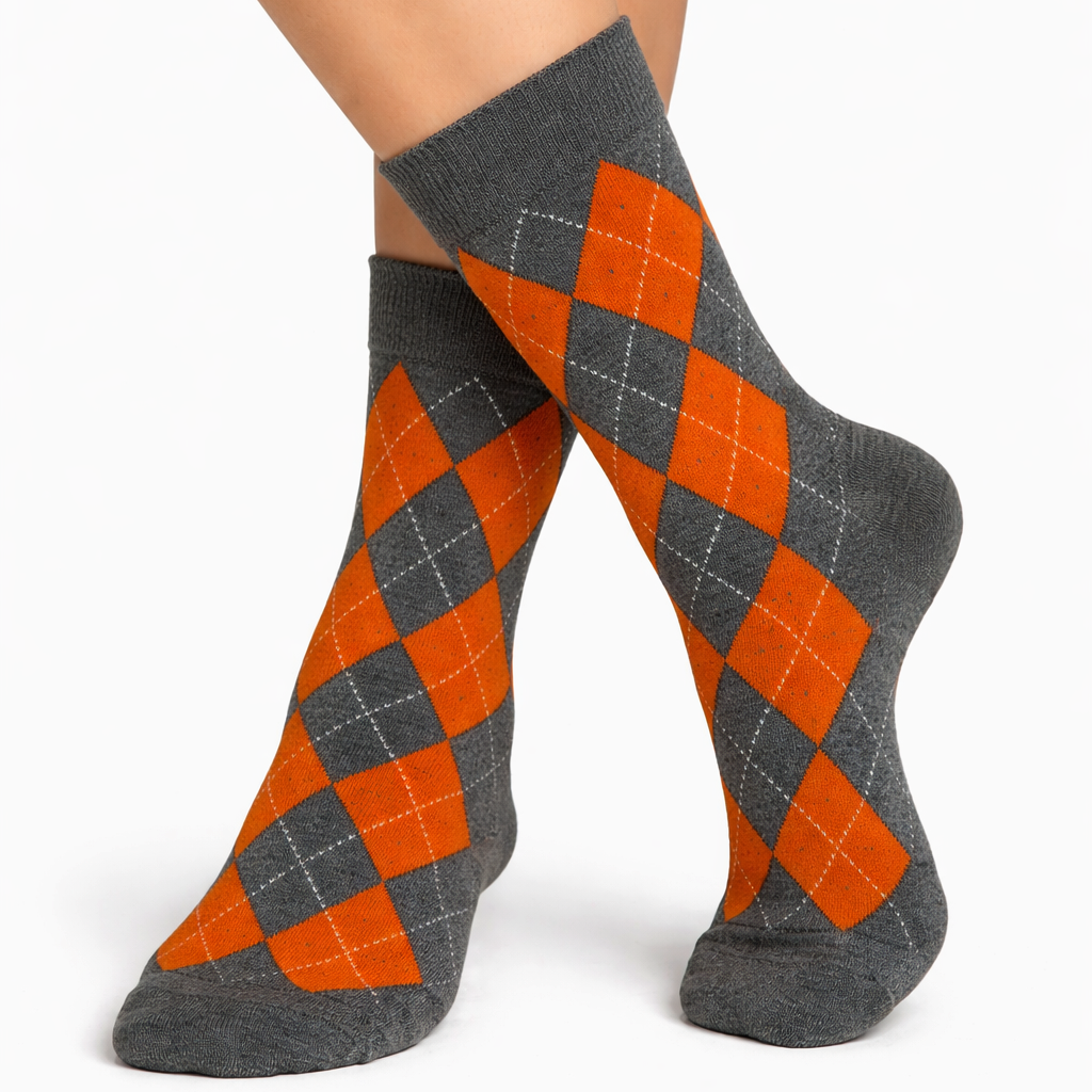 Gray and orange argyle socks worn by a person on a white background