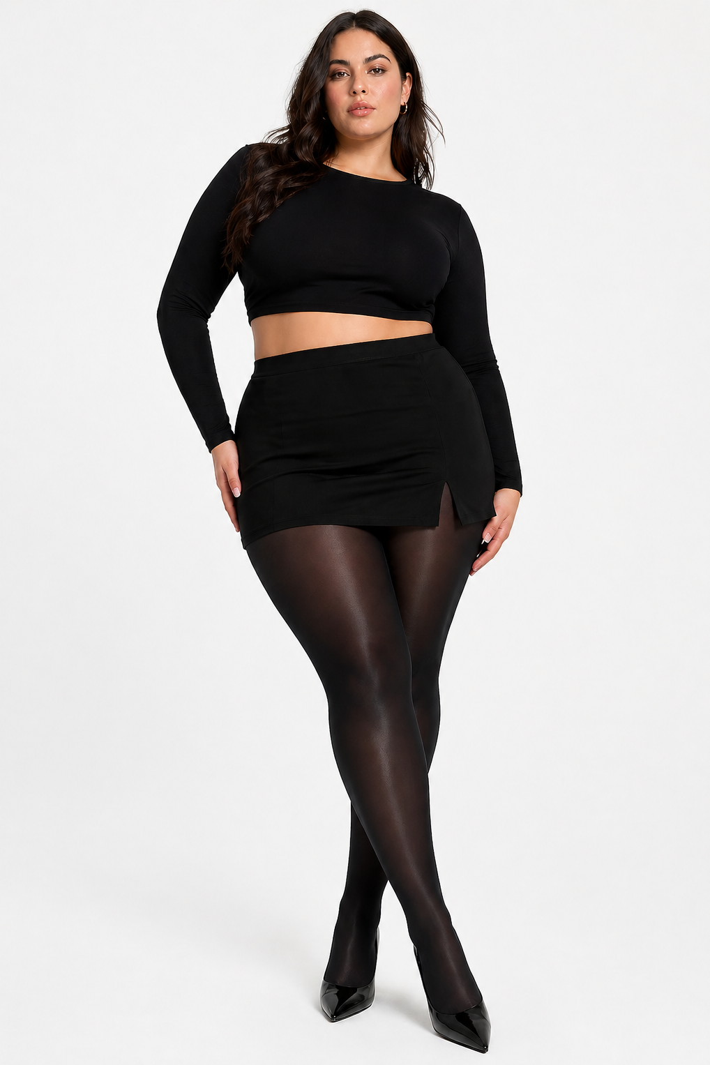 Woman wearing a black outfit with a skirt and tights on a white background