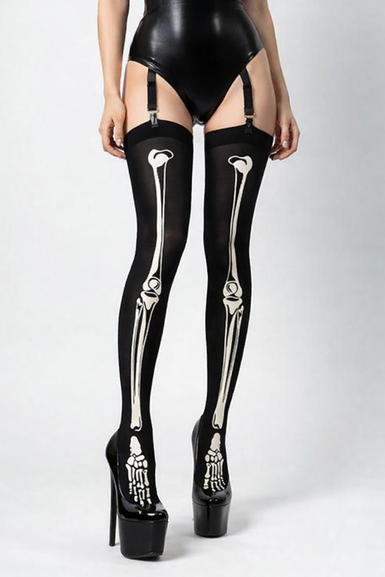 Person wearing a black latex bodysuit with skeleton design stockings on a white background