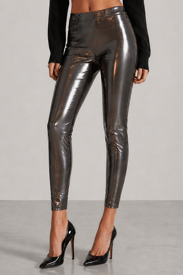 Woman wearing black turtleneck and metallic silver pants on a gray background