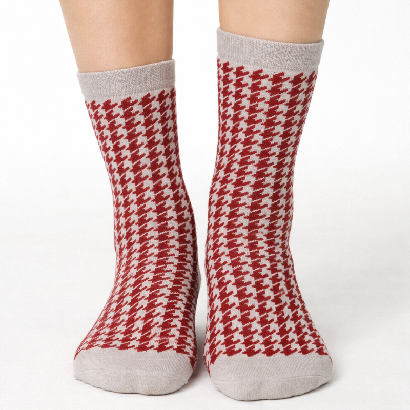 Red and white houndstooth patterned socks on a plain background