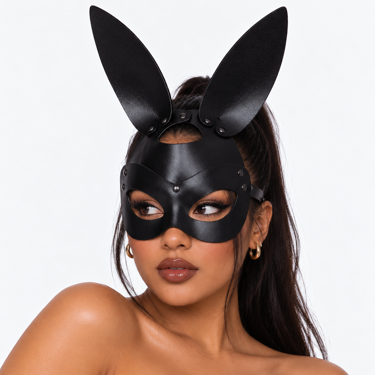 A woman wearing a black faux-leather bunny mask with tall upright ears, photographed against a clean light gray studio background.