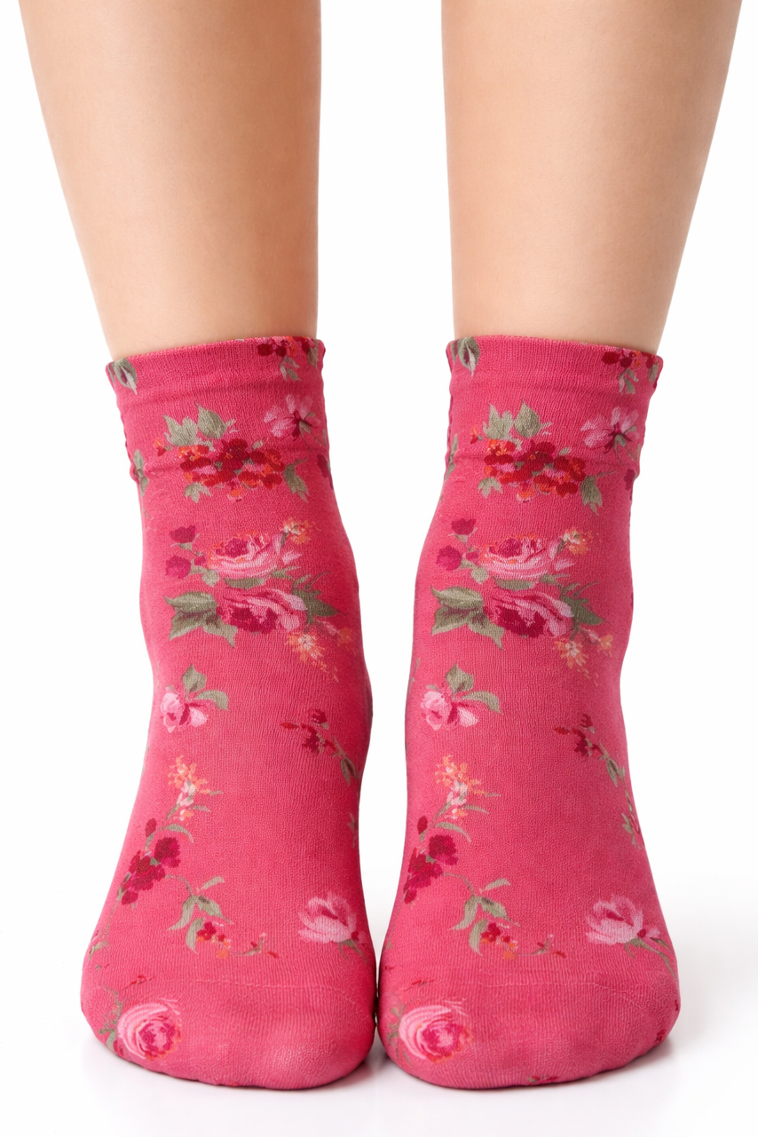 Pink floral socks worn by a person on a white background