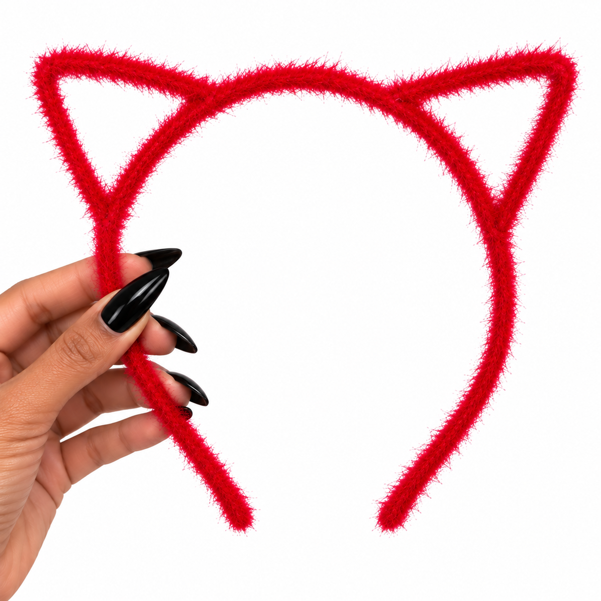 A red fuzzy pipe-cleaner cat ear headband held by a hand with long black manicured nails, set against a plain white background.