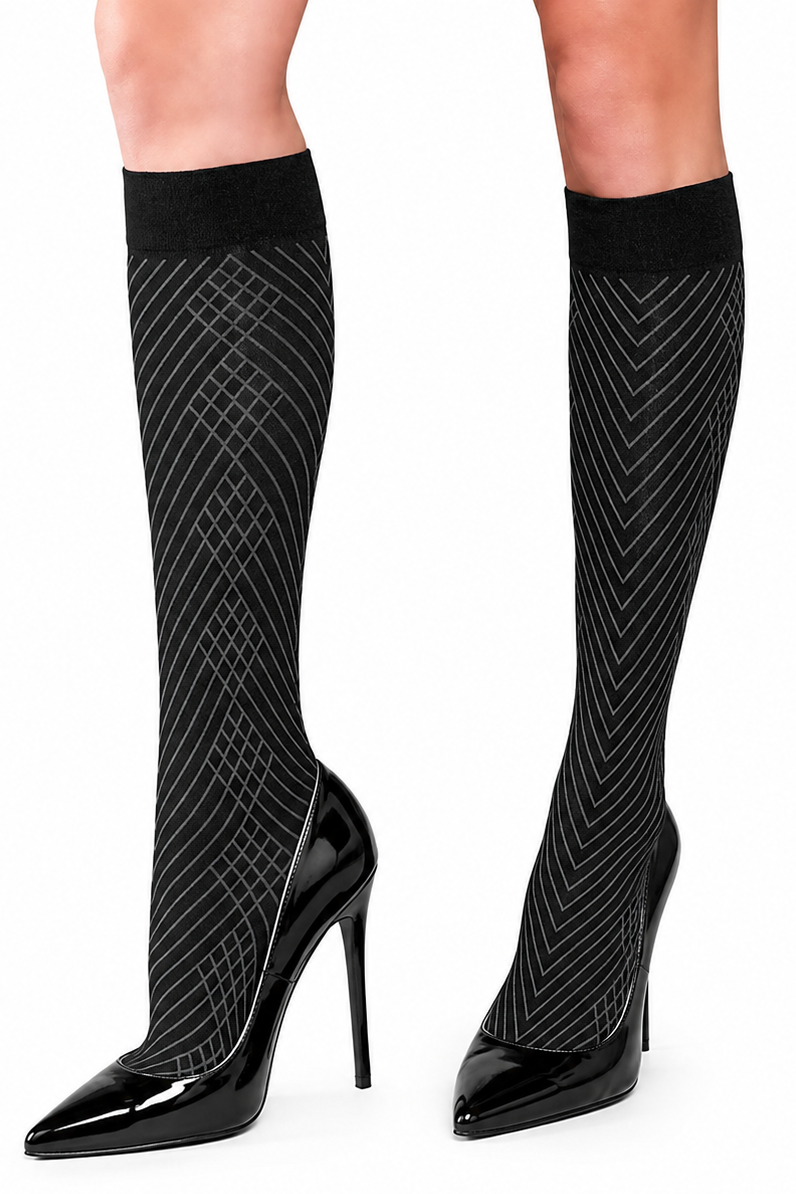 Black knee-high socks with a white geometric pattern, worn with black pointed-toe high heels against a plain white background.