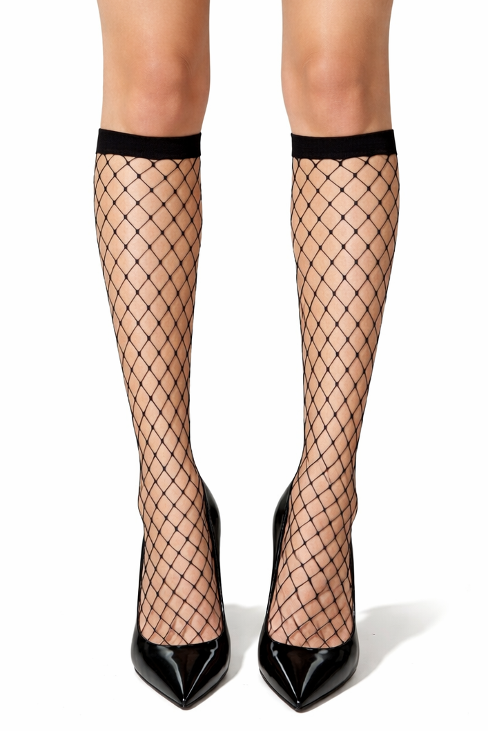 Person wearing black fishnet stockings and black high heels on a white background