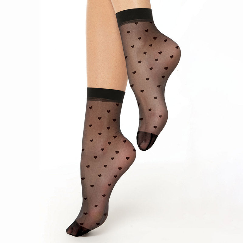 A pair of black sheer ankle socks with a heart pattern, displayed on a model's legs.